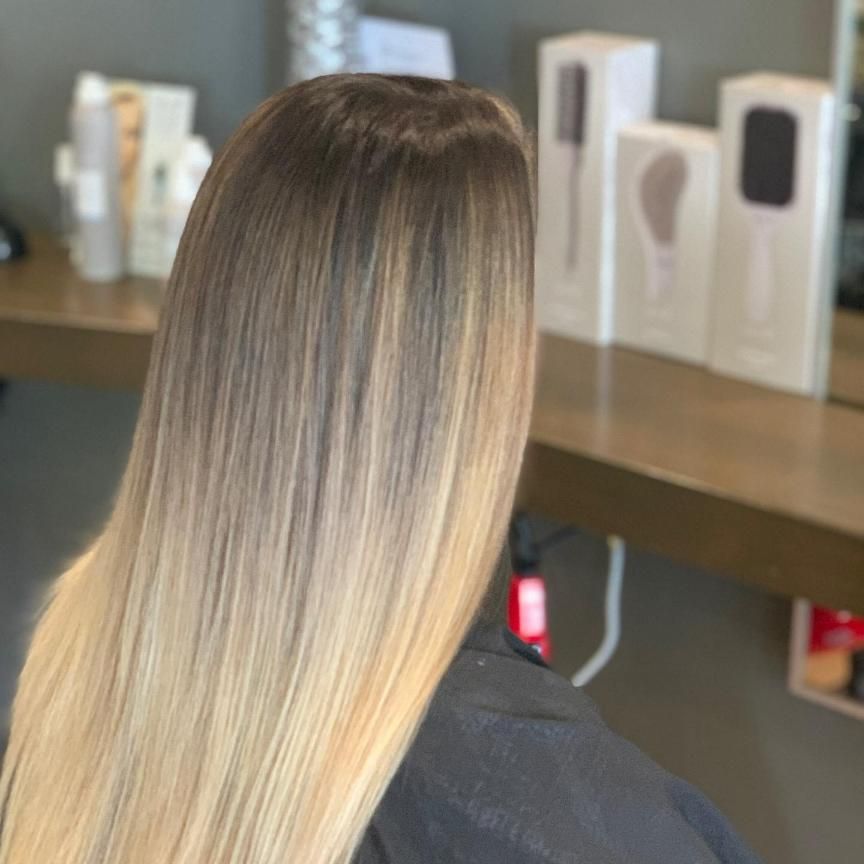 A Woman With Long Hair is Sitting in a Chair in Front of a Mirror — Energy Hair Co in Noosa Heads, QLD