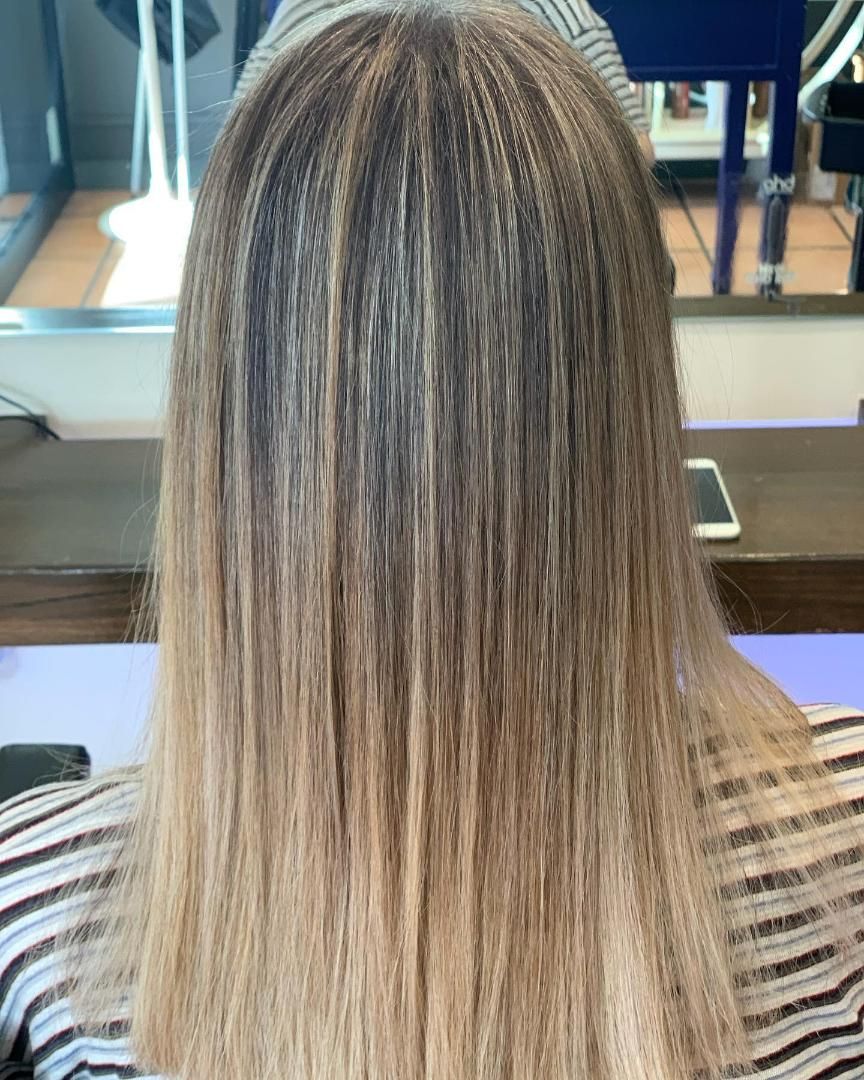 A Woman With Long Hair is Sitting in Front of a Mirror — Energy Hair Co in Noosa Heads, QLD