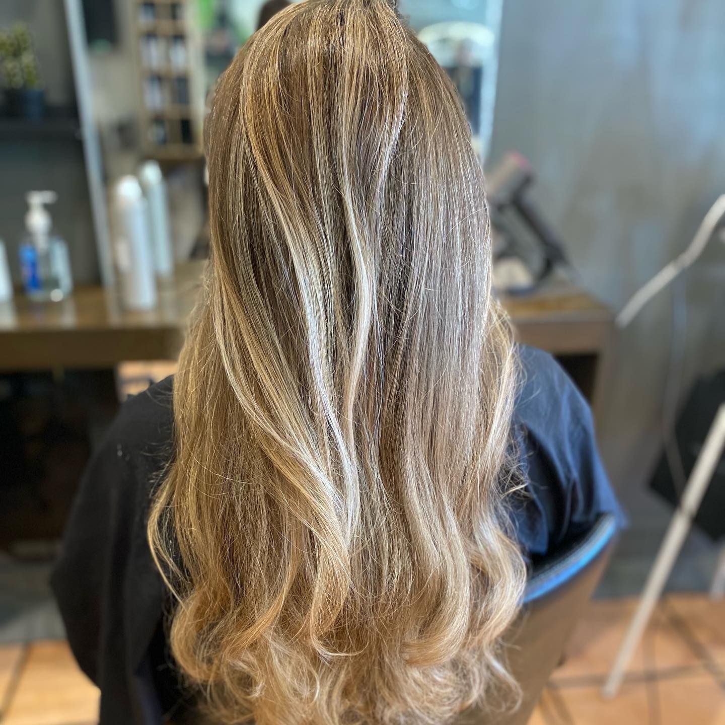 A Woman is Getting Her Hair Dyed by a Hairdresser in a Salon — Energy Hair Co in Noosa Heads, QLD