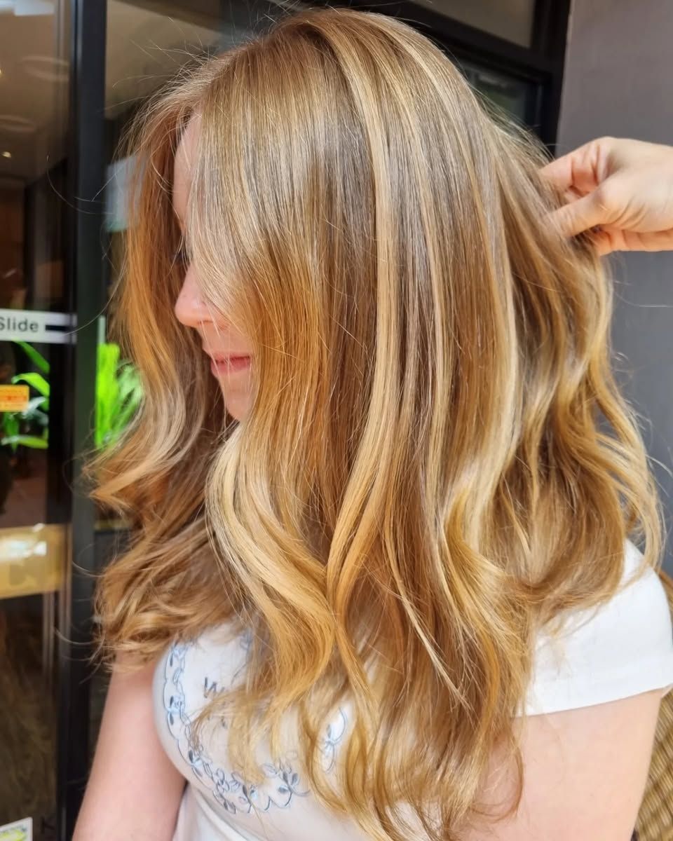 A Woman is Getting Her Hair Done by a Hairdresser in a Salon — Energy Hair Co in Noosa Heads, QLD
