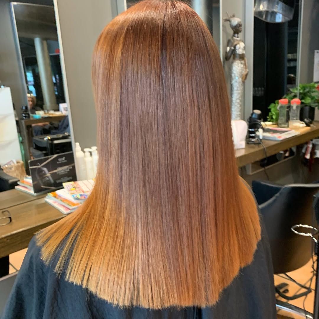 A Woman With Long Wavy Hair is Wearing a Black Dress — Energy Hair Co in Noosa Heads, QLD