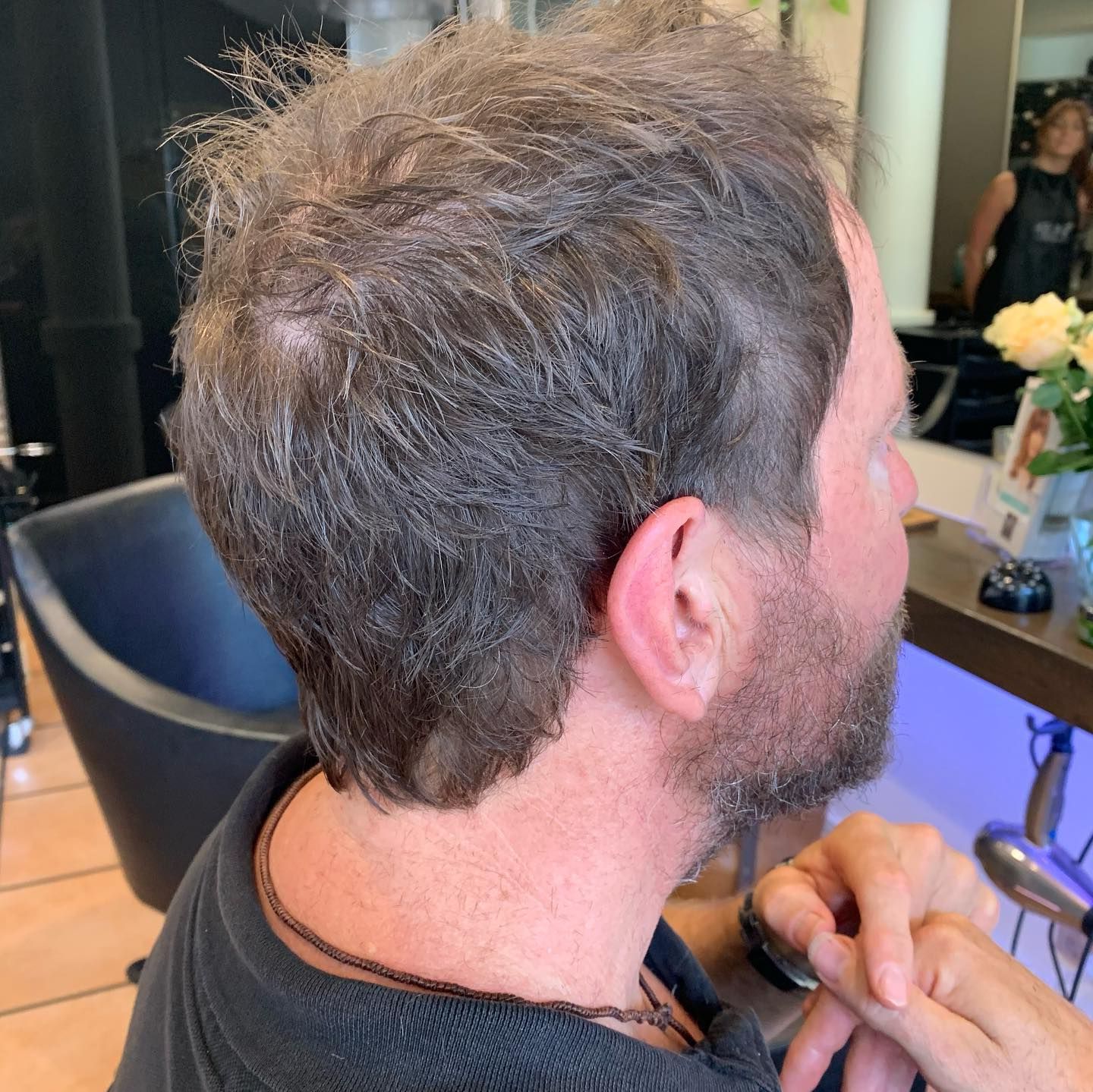 A Man is Getting His Hair Cut by a Barber in a Barber Shop — Energy Hair Co in Noosa Heads, QLD