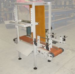 Industrial conveyor system with orange belt and protective frame.