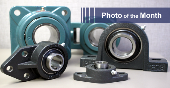 Various industrial pillow block bearings in teal and black, labeled 