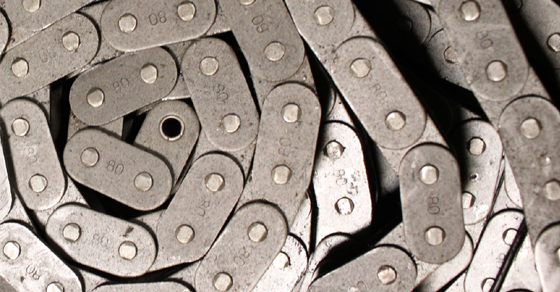 Close-up of a metal roller chain, with interconnected links and pins.