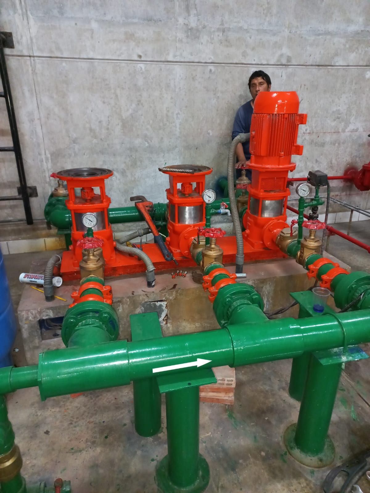 Tuberías industriales codificadas por colores con válvulas verdes y naranjas