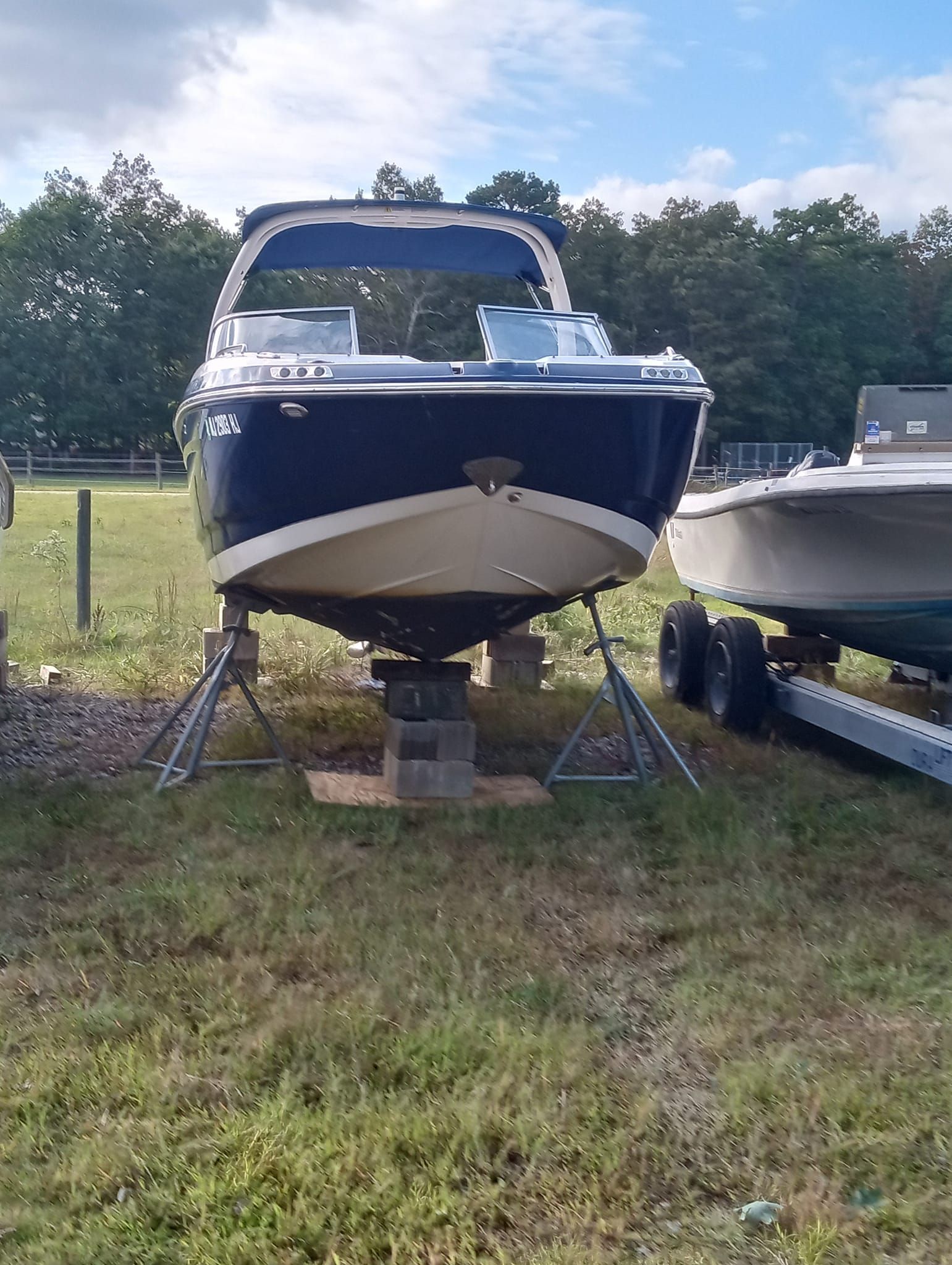 A truck is towing a boat down a street at night.