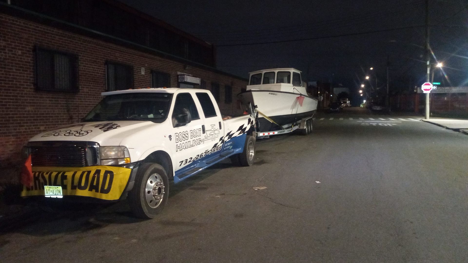 A boat is sitting on a trailer in a grassy field.
