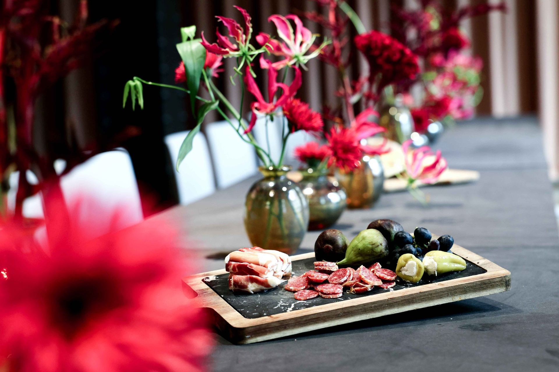 Antipasti-Platte mit Blumenvasen auf dem Tisch