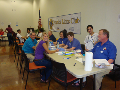 A group of people are sitting at tables in front of a sign that says virginia lions club