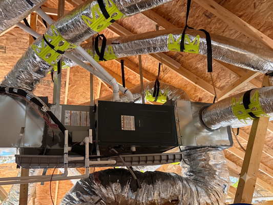 Electrician in blue shirt working on an electrical panel.