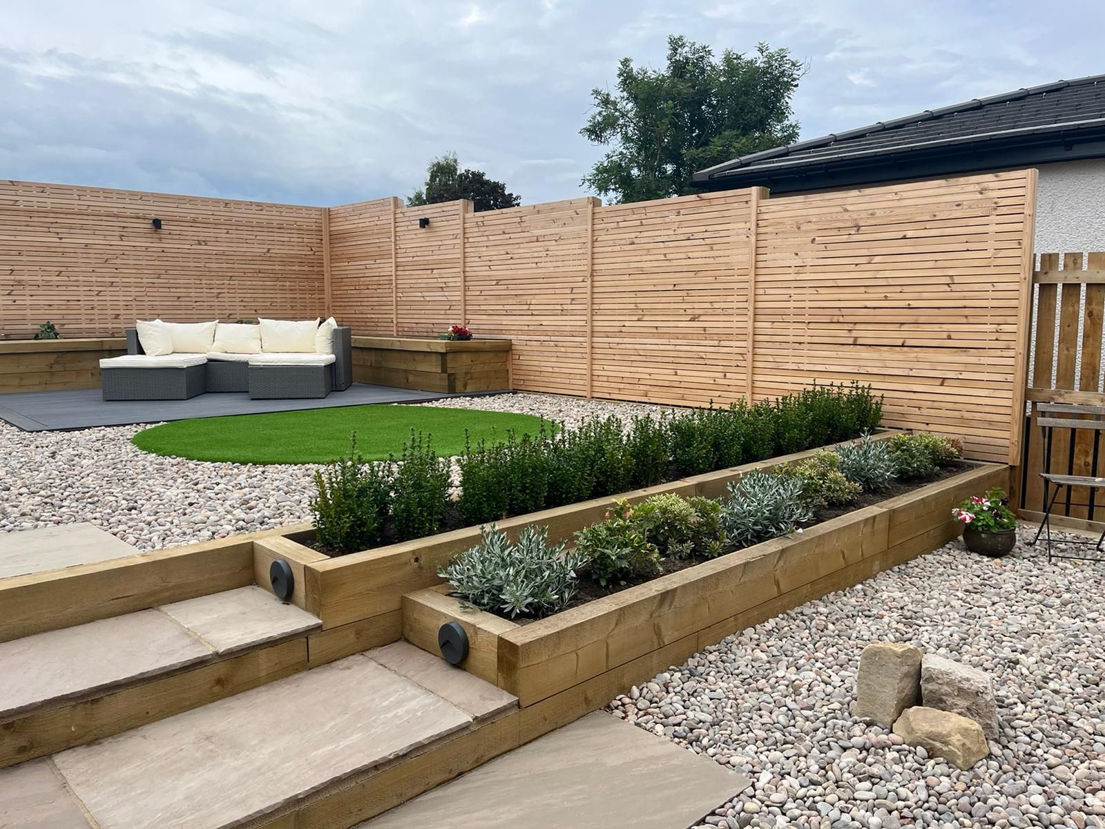 Dark gray wooden deck with a grassy lawn in the background.