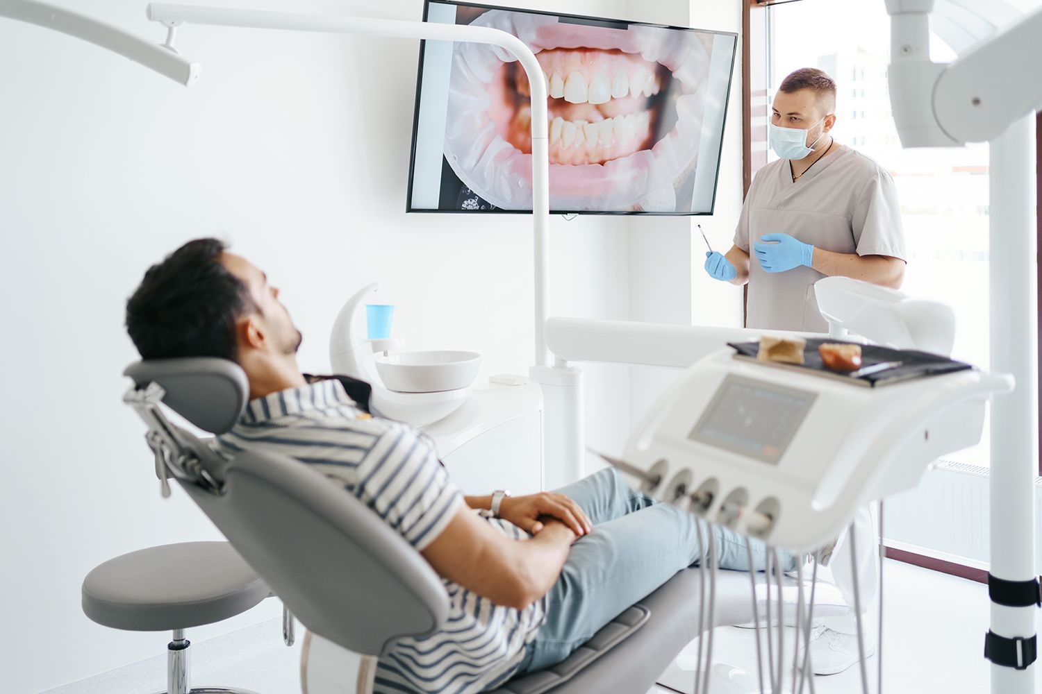 Dentist discussing with laying patient.