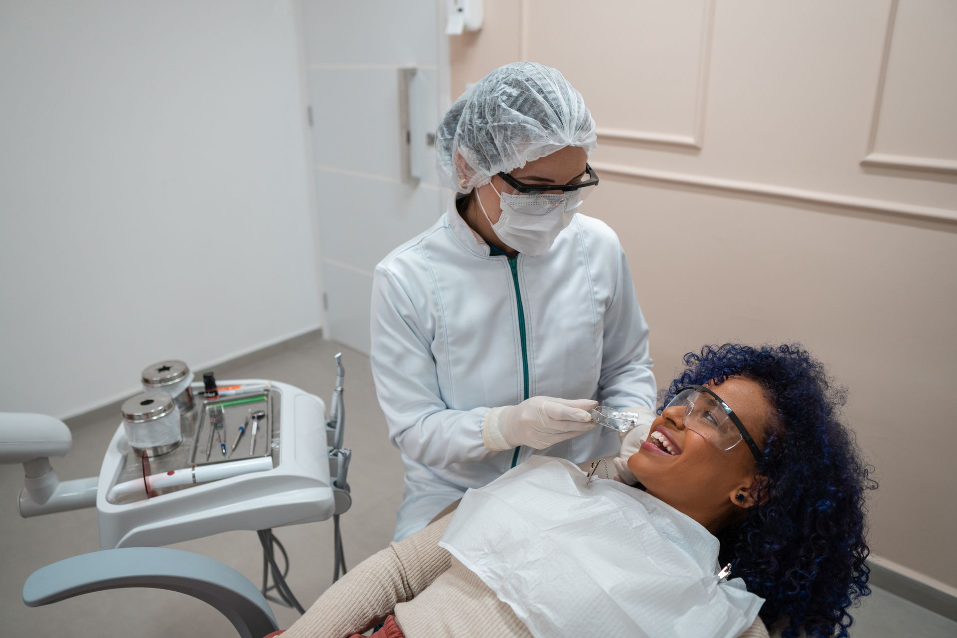 A woman smiling in a dental chair while receiving a check-up from a general dentist. A woman smiling in a dental chair while receiving a check-up from a general dentist.