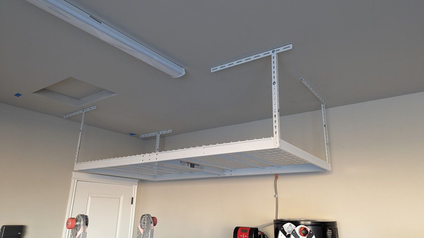 White overhead storage shelf mounted in a garage.