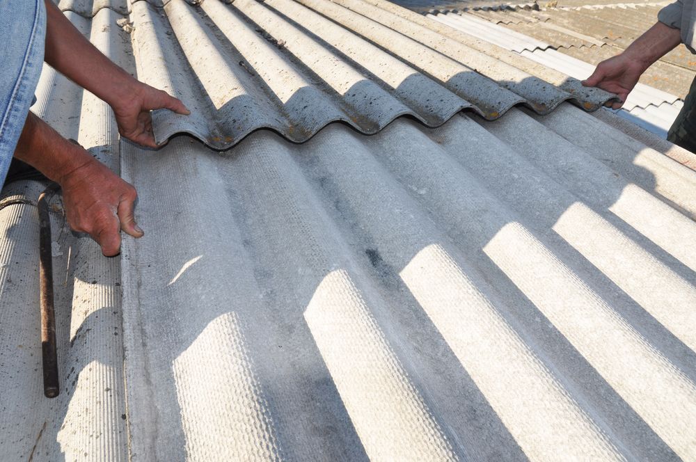 A Man Is Working On A Roof With A Hammer — Malouf Plumbing In Pie Creek, QLD