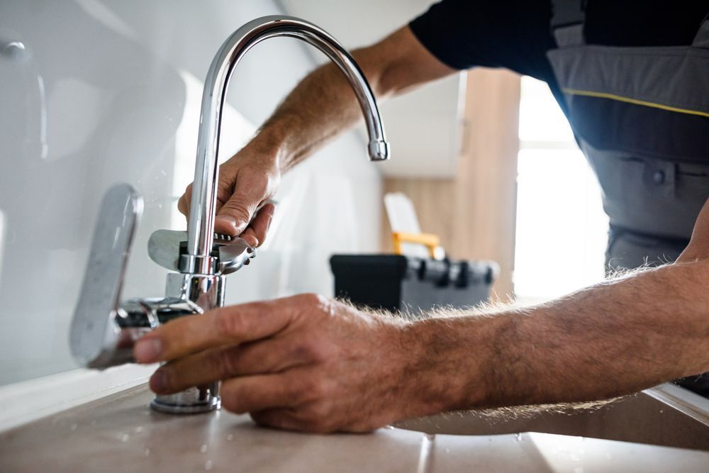 A Plumber Fixing The Faucet