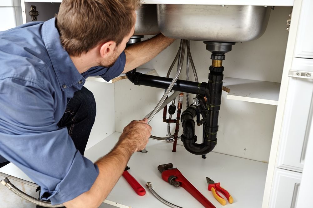 A Plumber Installing A New Pipe