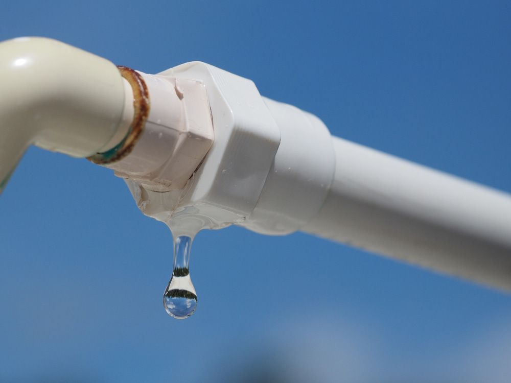 A White Pipe With A Drop Of Water Coming Out Of It — Malouf Plumbing In Pie Creek, QLD