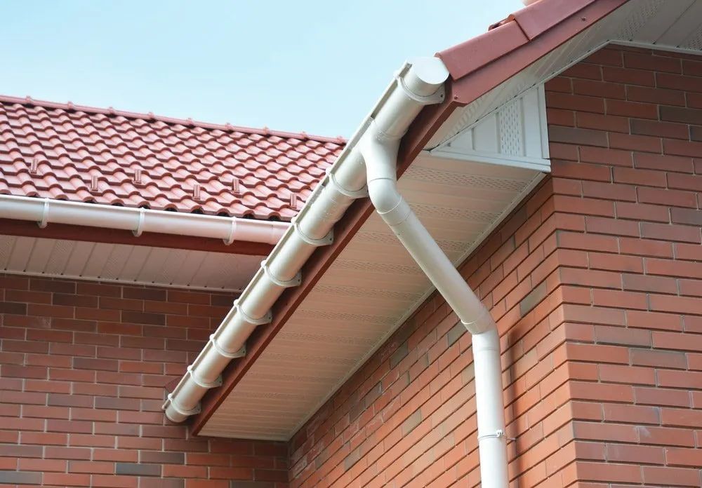 A Brick Building With A White Gutter On The Side — Malouf Plumbing In Pie Creek, QLD