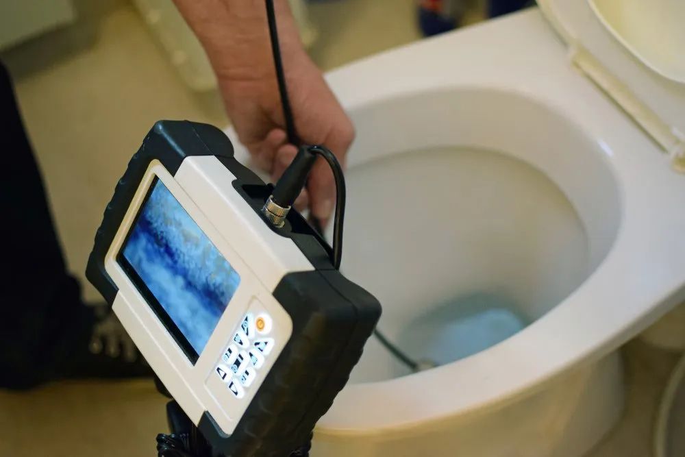 A Person Is Using A Camera To Look Into A Toilet — Malouf Plumbing In Pie Creek, QLD