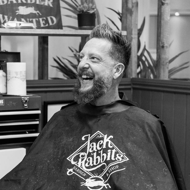 A man with a beard is wearing a jack rabbits cape