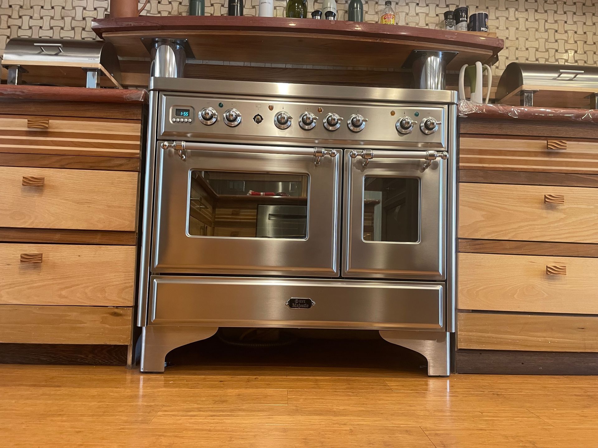 Stainless steel oven in a kitchen with wooden cabinets and countertop.