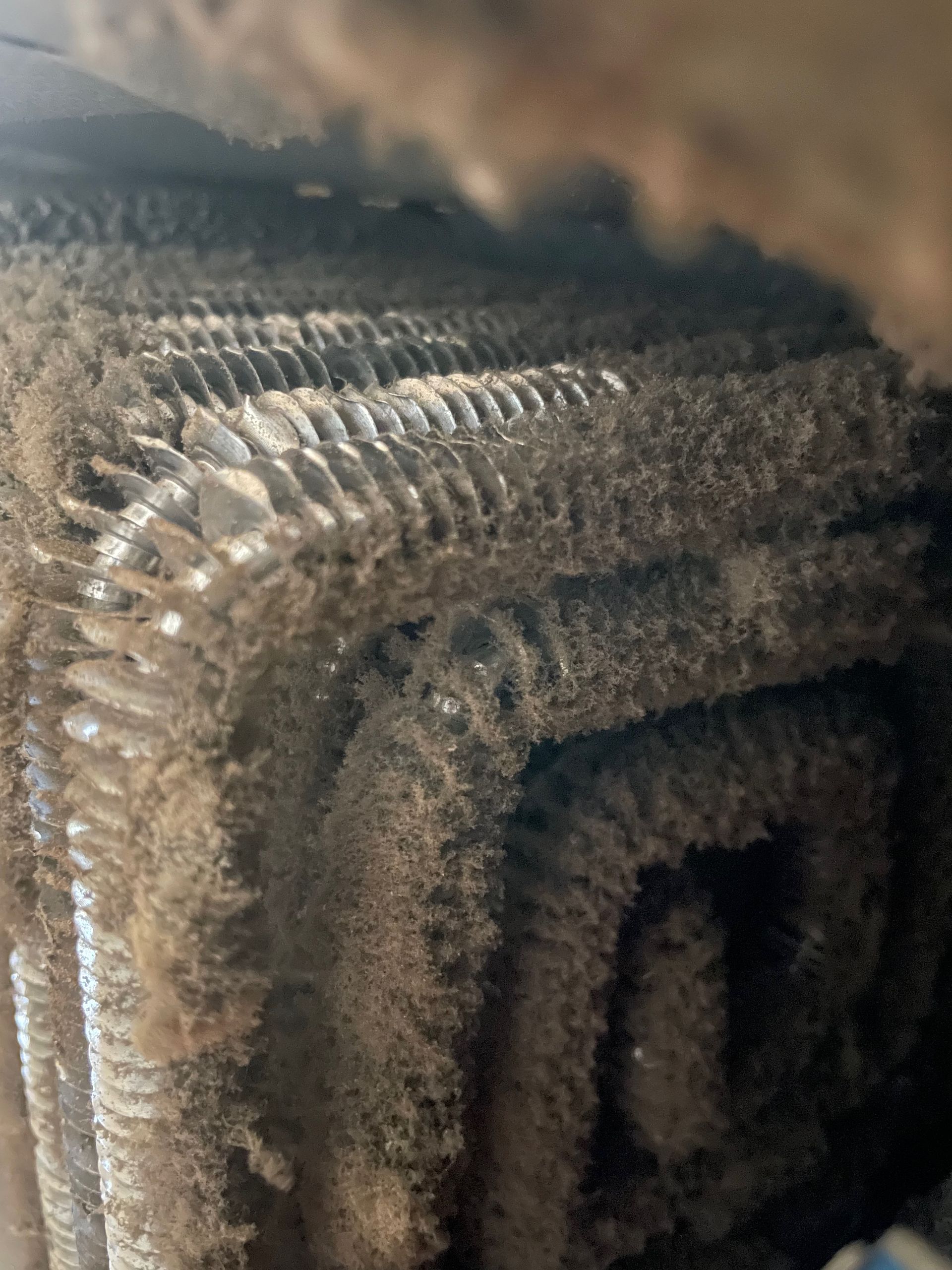 Close-up of a heavily dusty and dirty air conditioner coil.