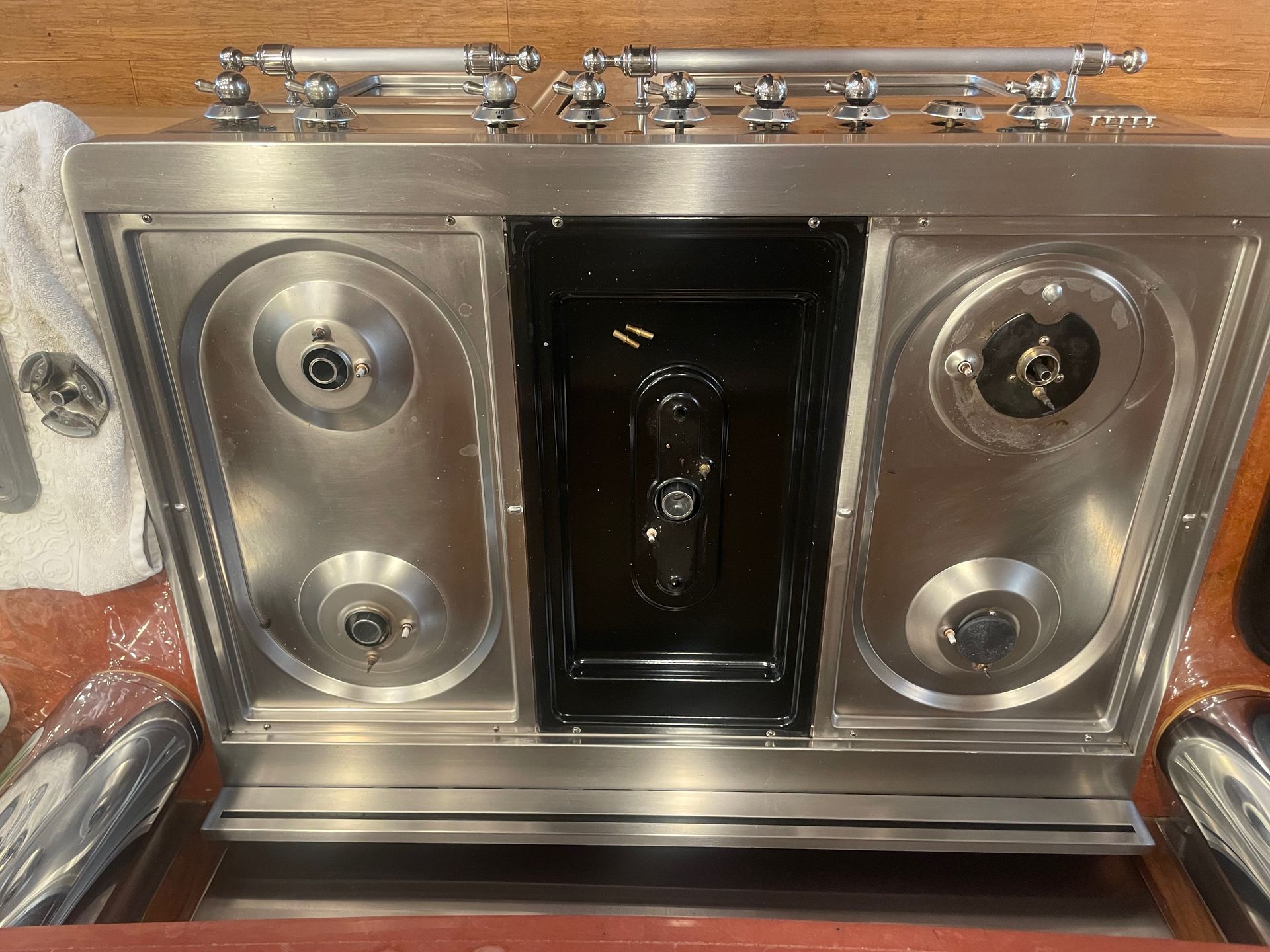 Stainless steel and black stove with four burners and an oven.