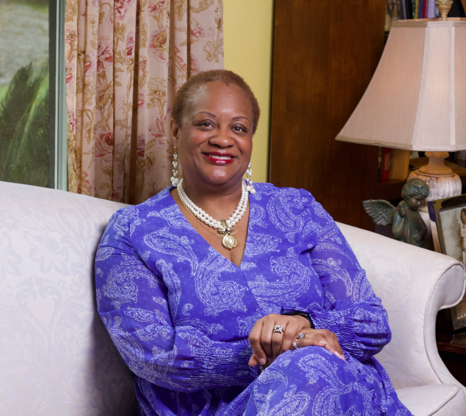 a woman in a purple dress is sitting on a couch
