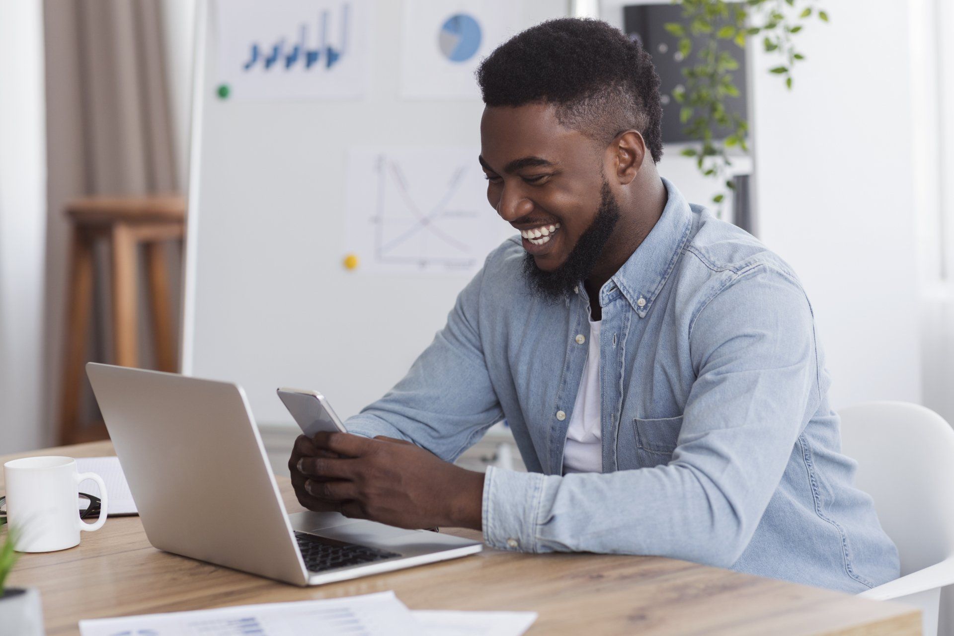 a man is sitting at a table using a laptop computer .