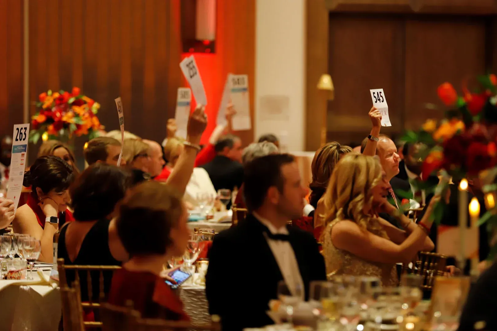 A group of people are sitting at a table holding up signs.