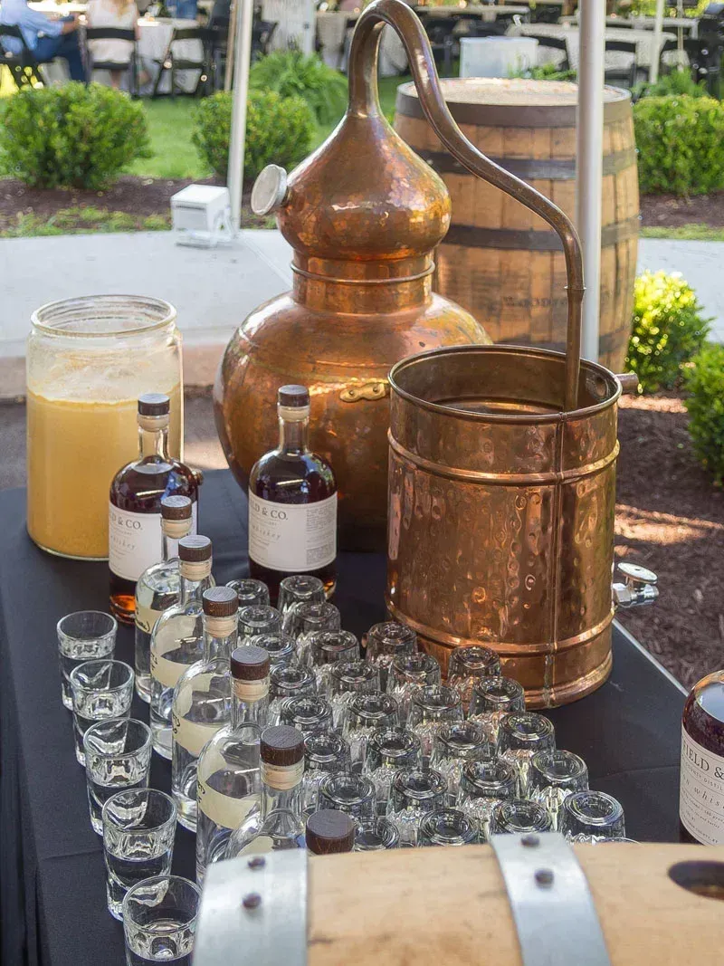 A table topped with bottles of liquor and shot glasses.