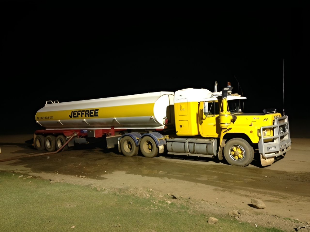 Yellow Jeffree fuel tanker truck parked at night on dirt.— Ts Jeffree Contractors in Burketown, QLD