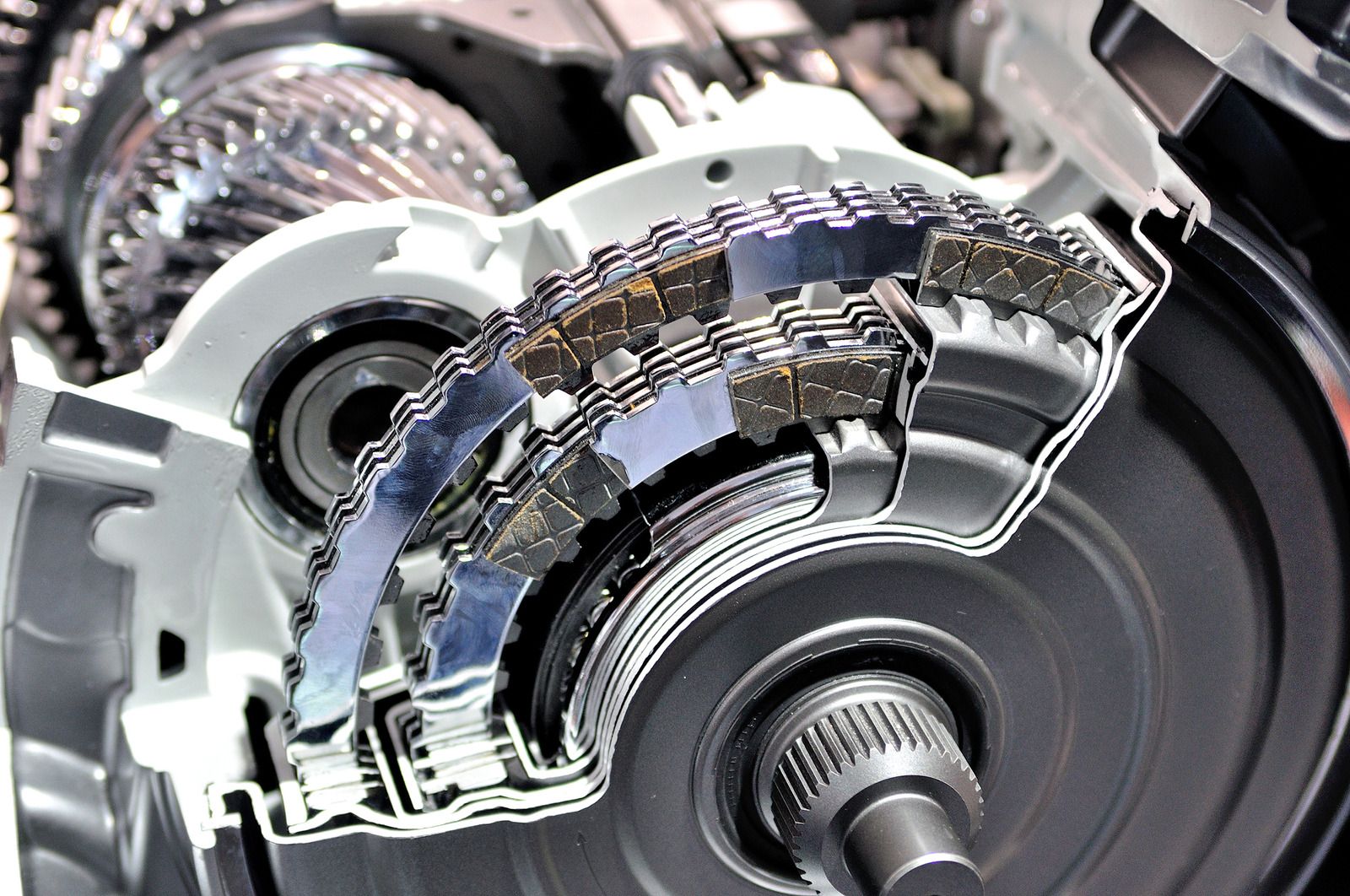 Mechanic working on car brake disc; hands touching caliper.