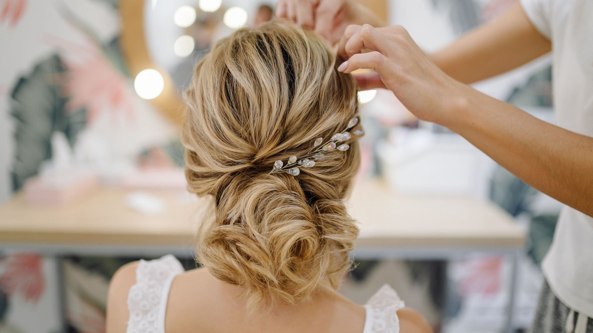 A woman is getting her hair done by a hairdresser in front of a mirror.