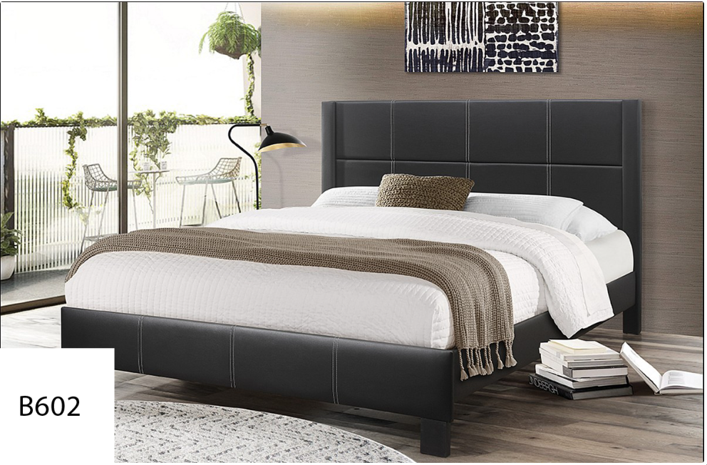 A bed with a black headboard and white sheets is in a bedroom.