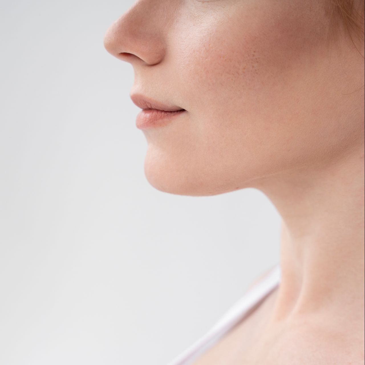Profile view of a person with fair skin, nose, lips, and chin, looking forward against a white background.