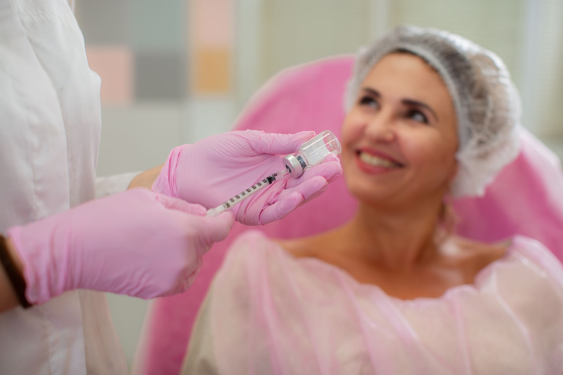 Gloved hand holding syringe near smiling patient in a spa or cosmetic treatment setting