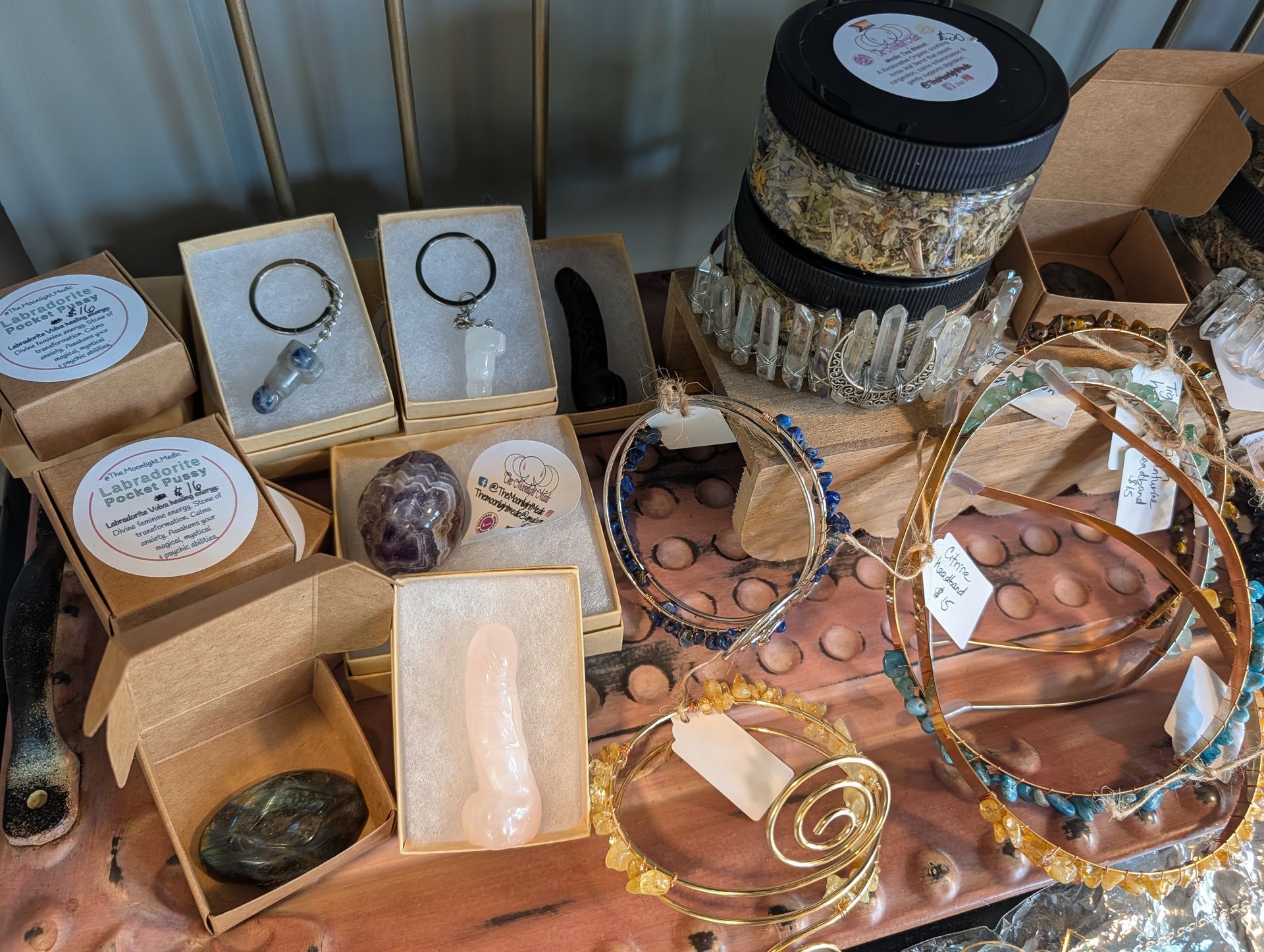 Assorted handmade jewelry and beaded accessories displayed on a table with boxes and tags