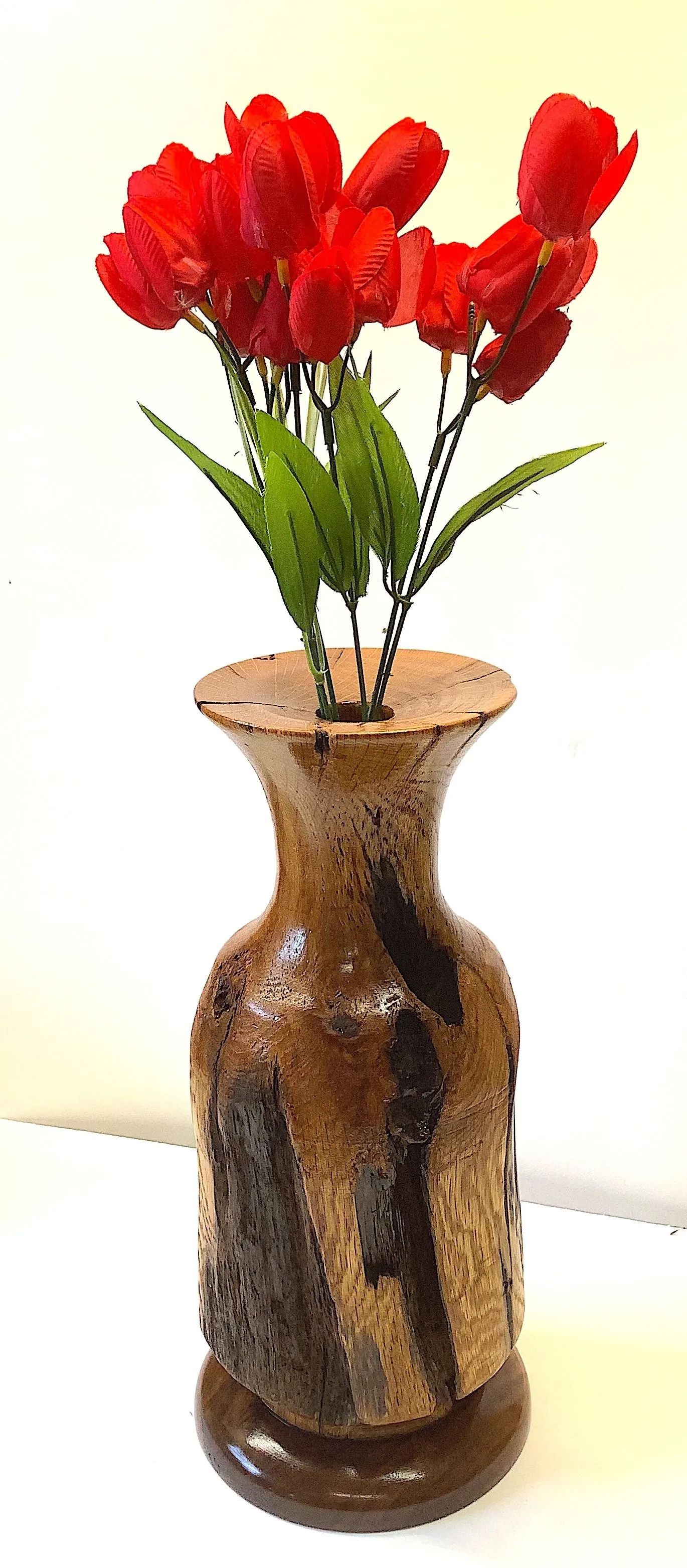 Brown vase with red flowers.