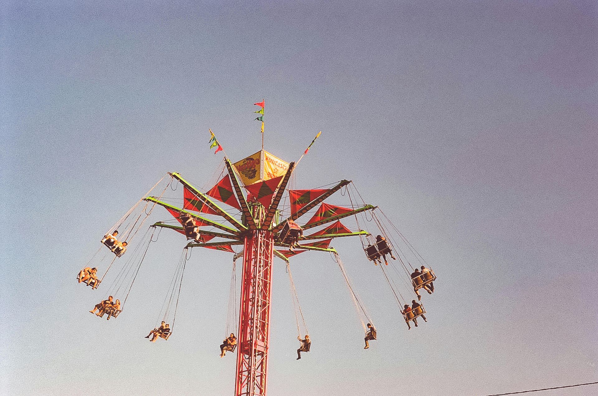 A ferris wheel with people riding it against a blue sky