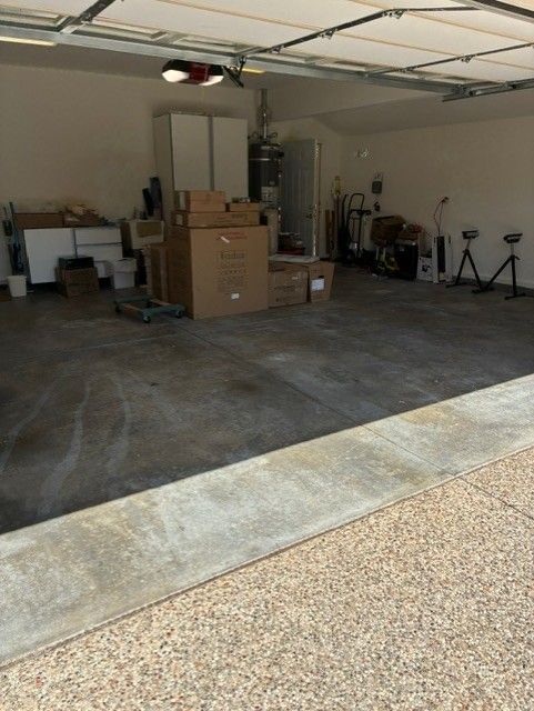 Cleanup King LLC - Garage interior with concrete floor, boxes, and storage.