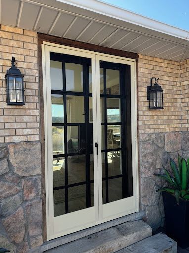 A white door with black trim is on a brick building.