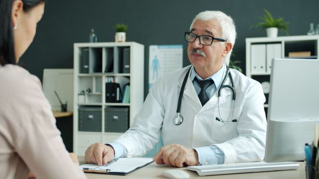 Physician reviewing medical records with a patient