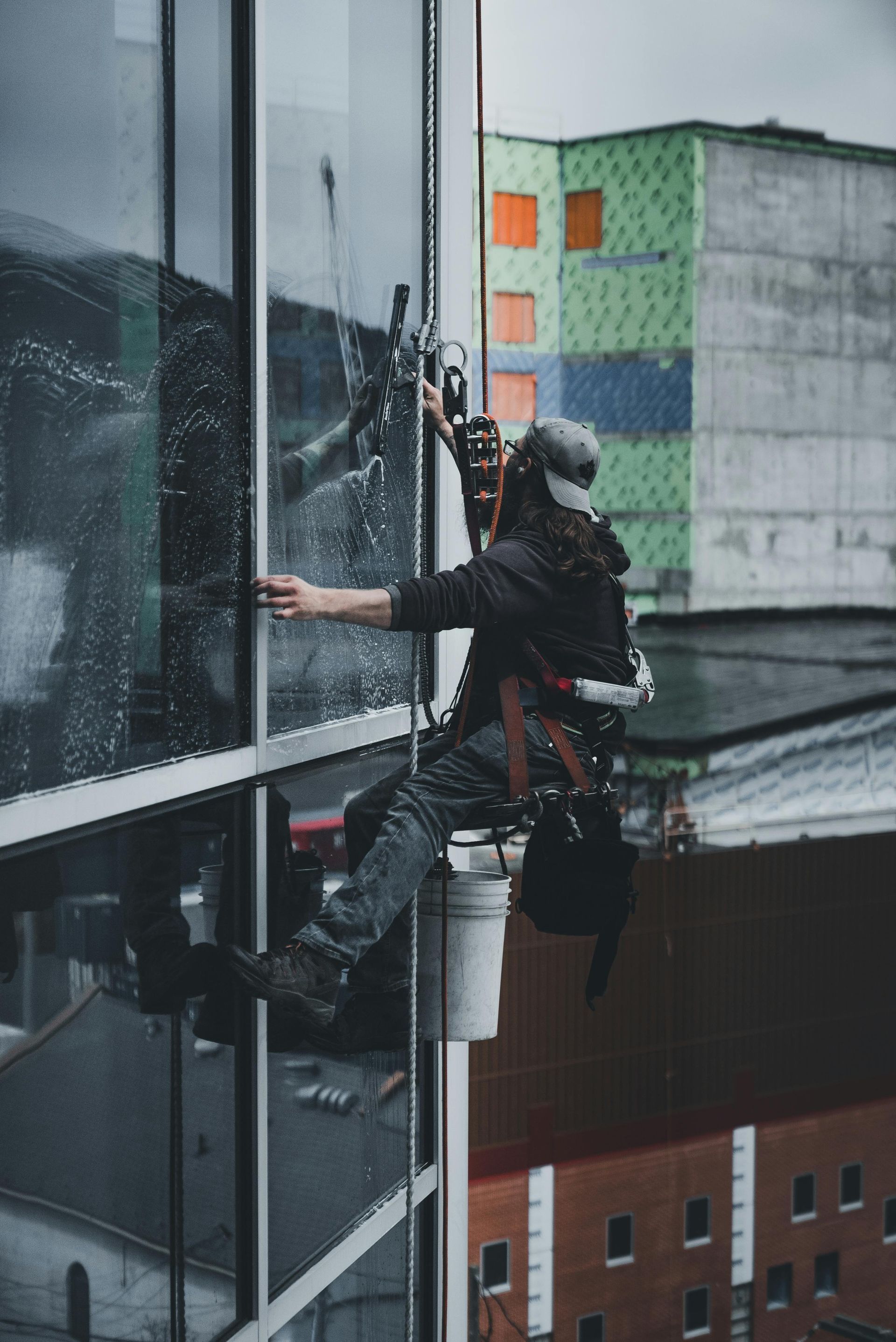 A man is cleaning a window with a squeegee.