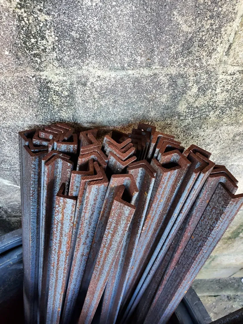 A bunch of rusty metal bars are stacked on top of each other.