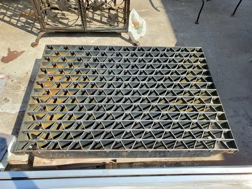 A metal grate is sitting on top of a wooden table.