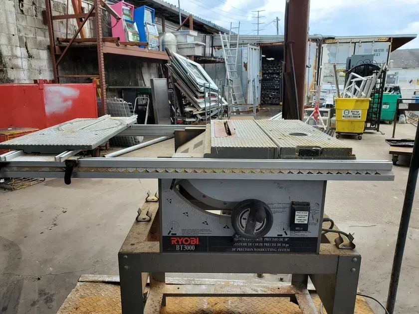 A table saw is sitting on top of a wooden table.