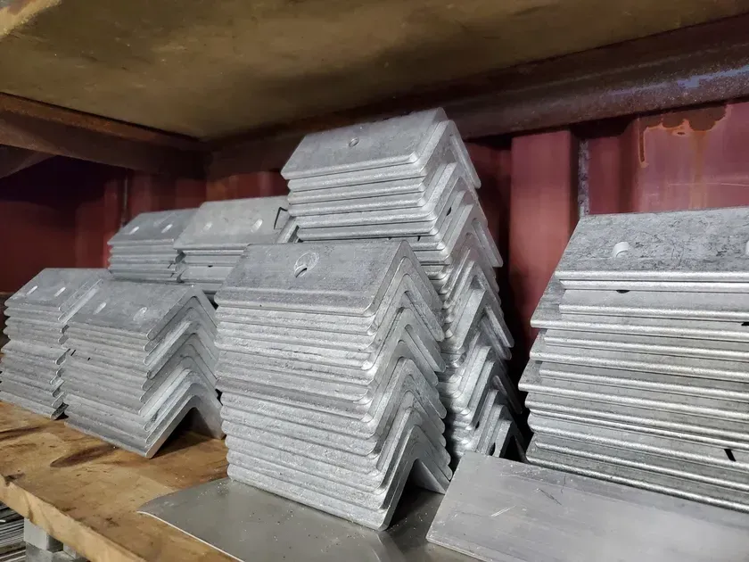 A stack of metal plates sitting on top of each other on a wooden shelf.